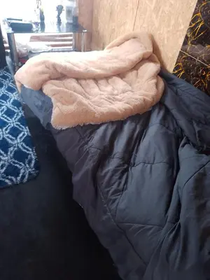 a blanket is laying on top of a bed at Bugambilia house in La Tinguiña