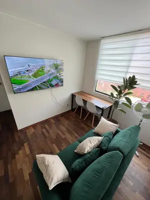 a living room with a green couch and a table at Departamento Prescott in Lima