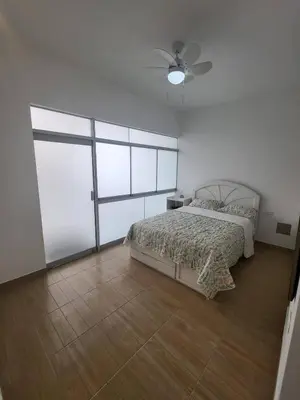 a bedroom with a bed and a ceiling fan at Little Oasis in Lima penthouse with pool, Grill, nice view, gated community in Ciudad de Dios