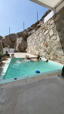 a man in a swimming pool with a frisbee at Little Oasis in Lima penthouse with pool, Grill, nice view, gated community in Ciudad de Dios