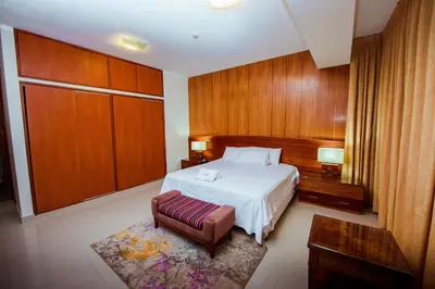 a hotel room with a bed and a chair at Grima Hotel in Huánuco