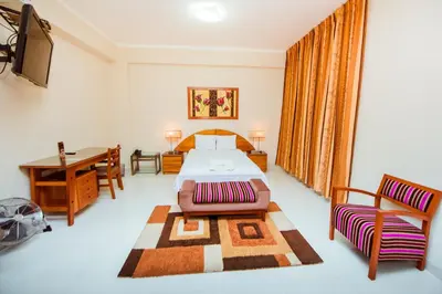 a bedroom with a bed and a table and a desk at Grima Hotel in Huánuco
