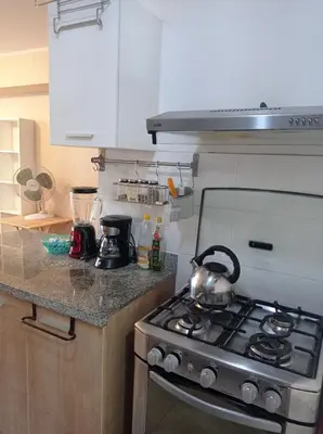 a kitchen with a stove with a tea kettle on it at Departamento en Santa Catalina in Lima