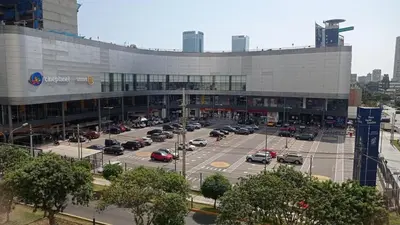 a parking lot with cars parked in front of a building at Departamento en Santa Catalina in Lima