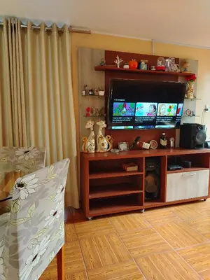 a living room with a flat screen tv on a entertainment center at Departamento en Sjl in Lima
