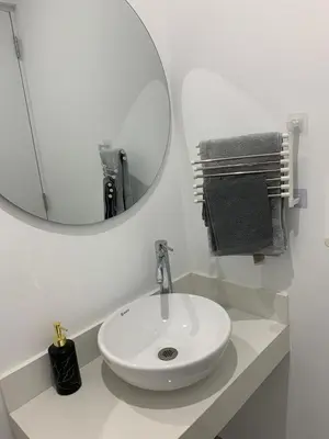 a white bathroom with a sink and a mirror at Full Depa en Miraflores in Lima