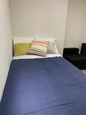 a bed with a blue comforter and two pillows at Full Depa en Miraflores in Lima