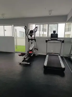 a gym with two exercise bikes and a treadmill at Departamento de Estreno in Lima