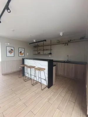 a kitchen with two tables and a counter in a room at Departamento de Estreno in Lima