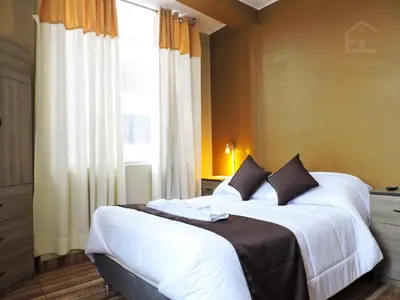 a bedroom with two beds and a window at EmbajadaWanka in Huancayo