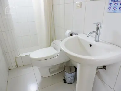 a white bathroom with a toilet and a sink at EmbajadaWanka in Huancayo