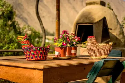 three baskets sitting on a wooden table with flowers at Las Cabañas de Tarii in Cieneguilla