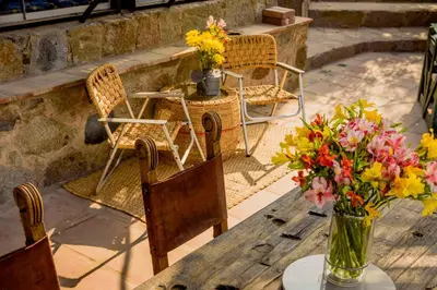 a table with chairs and a vase of flowers on it at Las Cabañas de Tarii in Cieneguilla