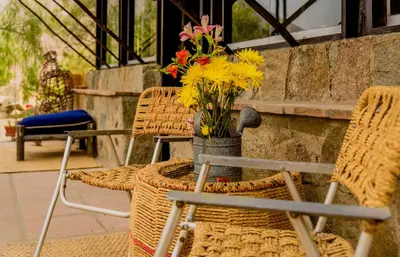a vase of flowers sitting on a table with chairs at Las Cabañas de Tarii in Cieneguilla