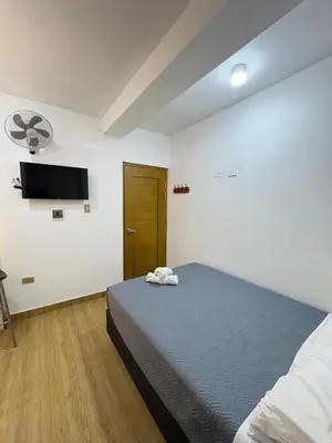 a bedroom with a bed and a flat screen tv at Hotel Costa Arena in Supe