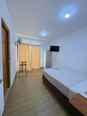 a bedroom with a bed and a flat screen tv at Hotel Costa Arena in Supe