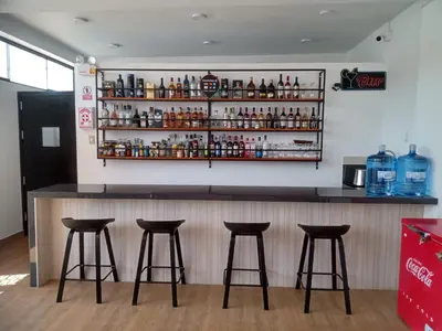 a bar with four stools in front of a counter at Hotel Costa Arena in Supe
