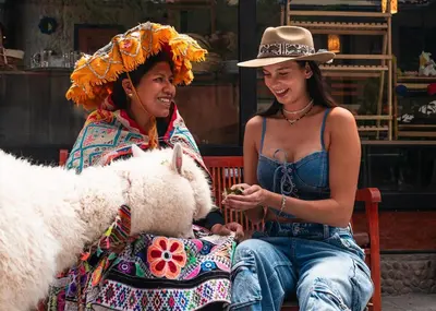 two women are sitting on a bench with a dog at Union Hotel Cusco in Cusco