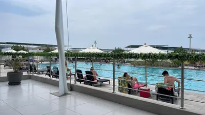 a group of people sitting in chairs next to a pool at Casa de Playa Hawi in San Antonio
