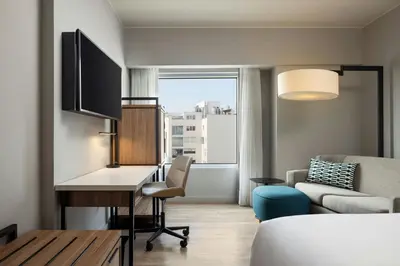 a room with a desk and a bed and a couch at Courtyard by Marriott Lima Miraflores in Lima