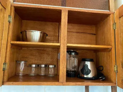 a wooden cabinet with a coffee maker and glasses at Family-friendly apartment! in Cusco