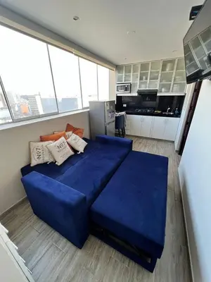 a large blue bed in a room with a kitchen at Miraflores Mini Apartment in Lima