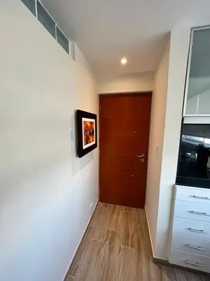 a hallway with a door and a television on a wall at Miraflores Mini Apartment in Lima