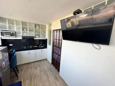 a kitchen with a large flat screen tv on the wall at Miraflores Mini Apartment in Lima