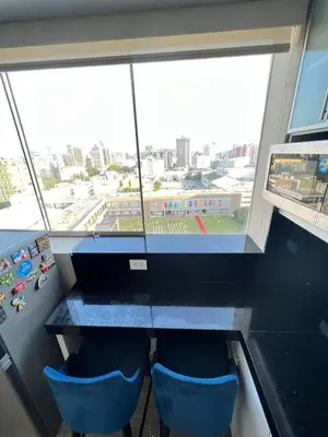 a room with a table and two blue chairs and a window at Miraflores Mini Apartment in Lima