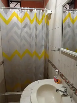 a bathroom with a sink and a shower curtain at Casa Halcones Huachipa Familia & Eventos in Lima