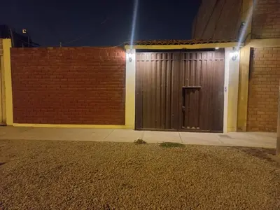 a pair of wooden doors on a building at night at Casa Halcones Huachipa Familia & Eventos in Lima