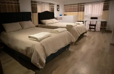two beds sitting next to each other in a bedroom at La Almudena hogar tranquilo y acogedor in Cusco