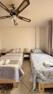 two beds in a room with a ceiling fan at Casa Amplia en Miraflores in Lima