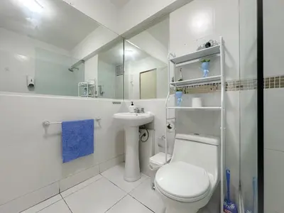 a white bathroom with a toilet and a sink at Miraflores 1 habitación in Lima