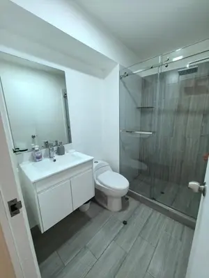 a bathroom with a toilet and a glass shower at Elegante Departamento vista al mar en Lima in Lima