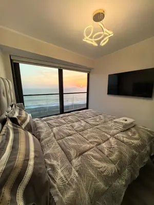 a bedroom with a bed and a large window at Elegante Departamento vista al mar en Lima in Lima