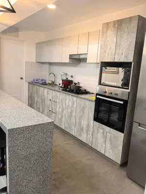 a kitchen with white cabinets and a counter top at Elegante Departamento vista al mar en Lima in Lima