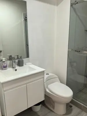 a bathroom with a toilet and a sink and a shower at Elegante Departamento vista al mar en Lima in Lima