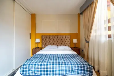 a bedroom with a bed with a checkered blanket at Classy Andino & primer piso, 2 dormitorios in Lima