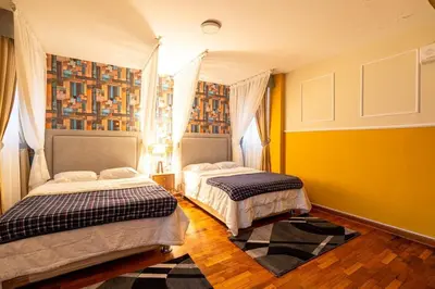 two beds in a room with yellow walls at Classy Andino & primer piso, 2 dormitorios in Lima