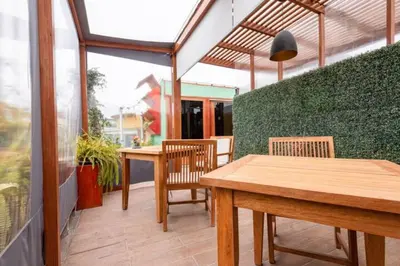 a patio with two tables and chairs and a green wall at Classy Andino & primer piso, 2 dormitorios in Lima