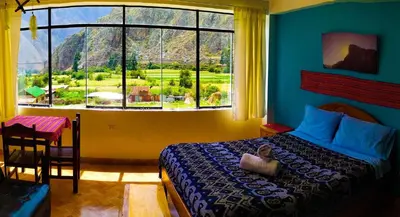 a bedroom with a bed and a large window at Mountainview House Ollantaytambo in Ollantaytambo