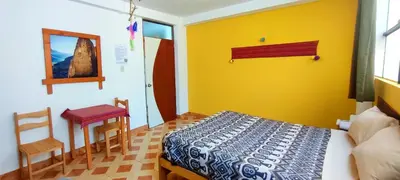 a bedroom with a bed and a table and a chair at Mountainview House Ollantaytambo in Ollantaytambo