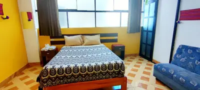 a bedroom with a bed and a blue couch at Mountainview House Ollantaytambo in Ollantaytambo
