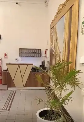 a lobby with a desk with a plant in a pot at Colville Hospedaje, a 1 cuadra de la plaza mayor de lima in Lima