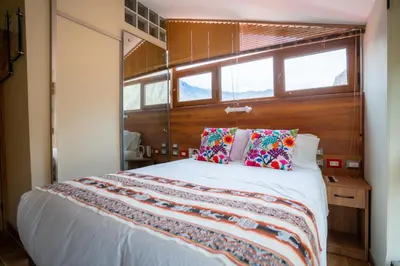 a bedroom with a large white bed with colorful pillows at Hotel Boutique PLAZA GIBAJA in Ollantaytambo