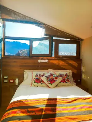 a bedroom with a bed with two pillows and a window at Hotel Boutique PLAZA GIBAJA in Ollantaytambo
