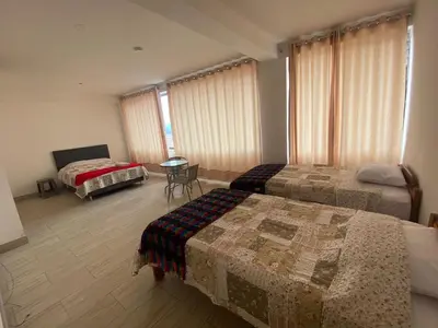 a hotel room with two beds and a table at Casa Moriáh in Maras