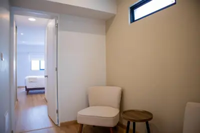 a room with a white chair and a window at Aguirre By Wynwood House in Lima