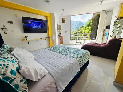 a bedroom with a bed with a tv and a balcony at PIERO HOUSE - La Merced in La Merced